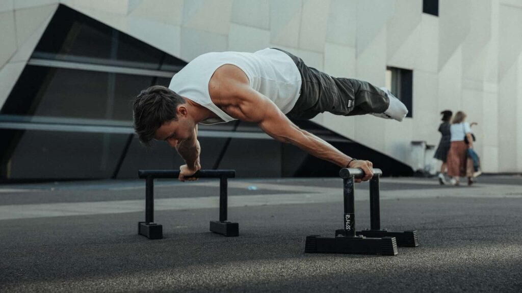 a man doing push ups on bars